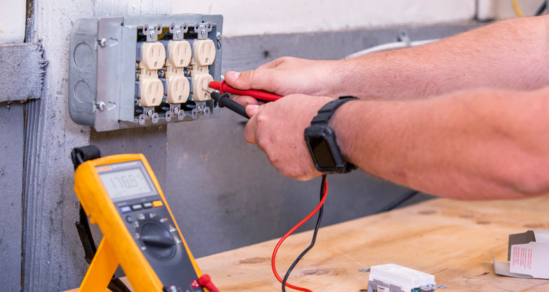 Electrician testing an electrical socket.